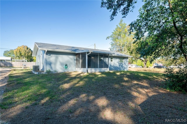 back of house with a sunroom, central air condition unit, and a yard