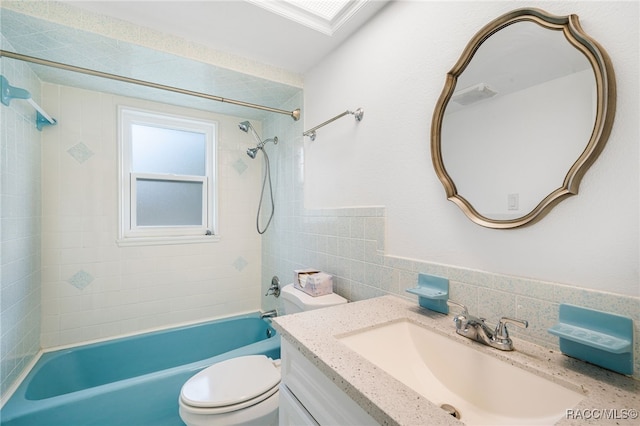 full bathroom with tiled shower / bath combo, backsplash, toilet, vanity, and tile walls