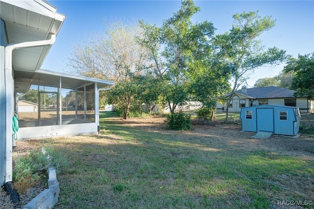 view of yard featuring a sunroom and a storage shed