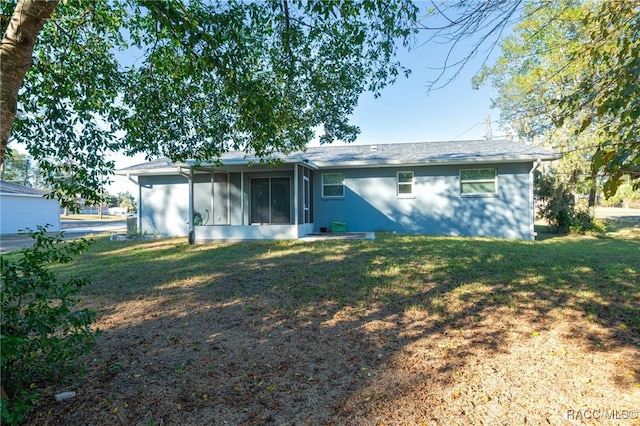 back of property featuring a yard and a sunroom