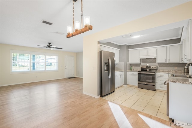 kitchen featuring white cabinetry, sink, stainless steel appliances, pendant lighting, and ceiling fan with notable chandelier