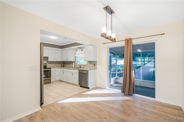 kitchen with white cabinetry, sink, stainless steel appliances, light hardwood / wood-style flooring, and pendant lighting