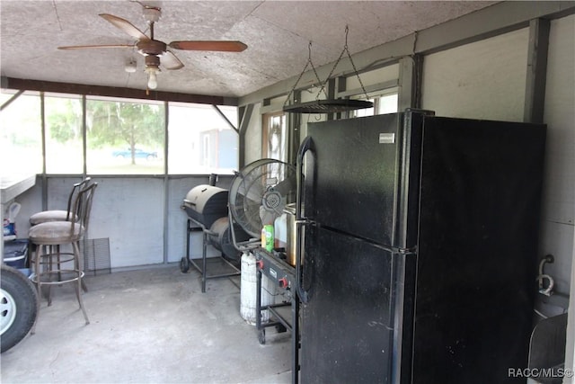 interior space with ceiling fan and freestanding refrigerator