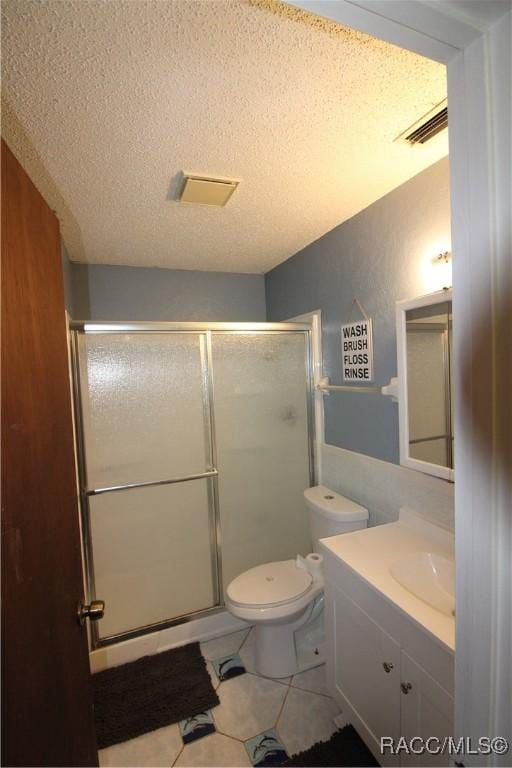 full bath with visible vents, vanity, a textured ceiling, a shower stall, and tile patterned floors