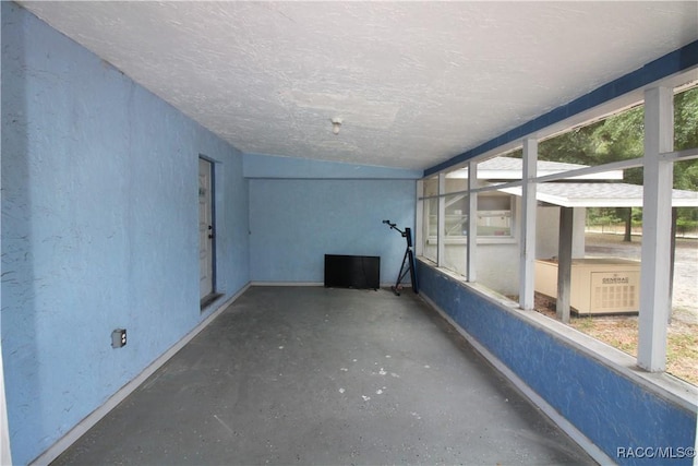 interior space featuring concrete flooring and a textured wall