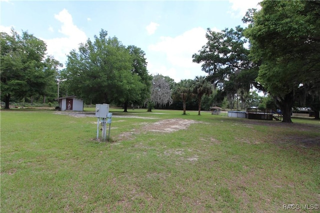 view of yard featuring a storage shed and an outbuilding