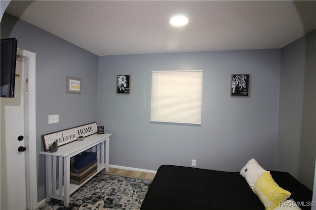 bedroom featuring baseboards and wood finished floors