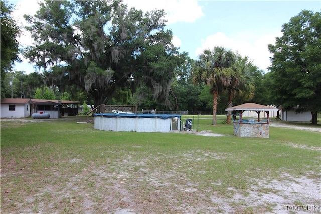 view of yard with a gazebo, a carport, and a covered pool