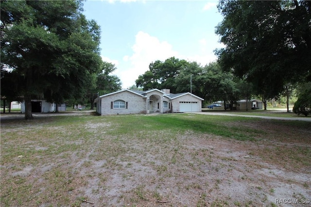 ranch-style house with an attached garage and a chimney