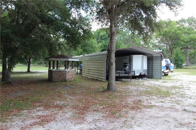 exterior space featuring dirt driveway and a carport