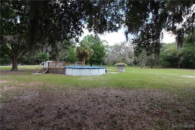 view of yard with a deck and an outdoor pool