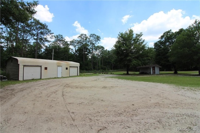 view of yard with an outdoor structure and a detached garage