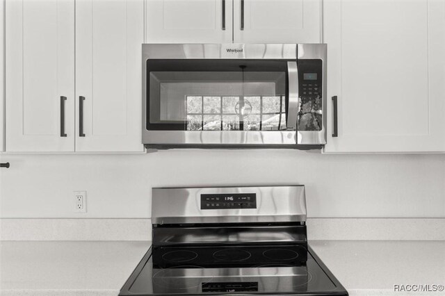 interior details with stainless steel appliances, white cabinetry, and light countertops