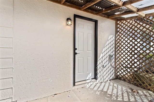 view of exterior entry with stucco siding