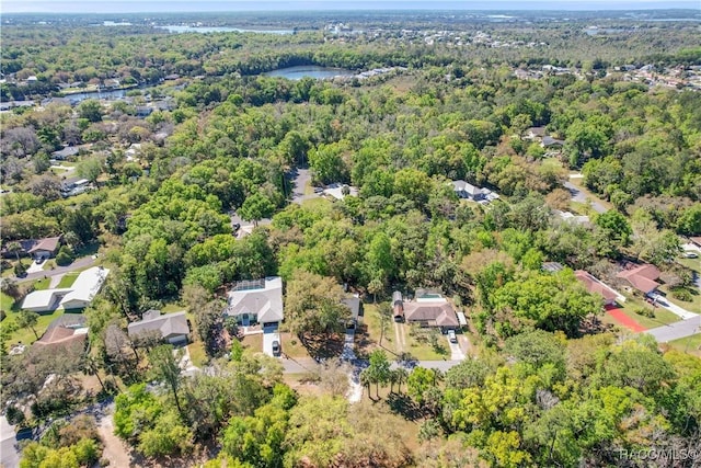 aerial view featuring a residential view, a wooded view, and a water view