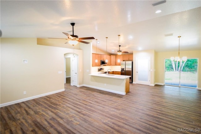 interior space with kitchen peninsula, appliances with stainless steel finishes, hanging light fixtures, and sink