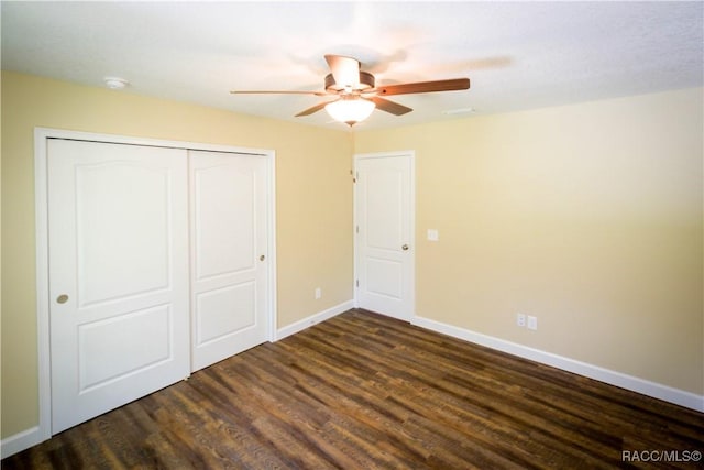 unfurnished bedroom featuring dark hardwood / wood-style flooring, ceiling fan, and a closet