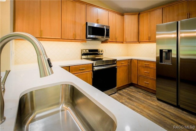 kitchen featuring decorative backsplash, dark hardwood / wood-style flooring, stainless steel appliances, and sink