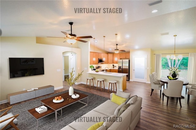 living room featuring dark hardwood / wood-style flooring, sink, ceiling fan with notable chandelier, and lofted ceiling