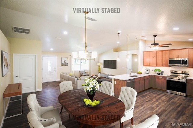 dining space featuring dark hardwood / wood-style flooring, sink, ceiling fan with notable chandelier, and vaulted ceiling