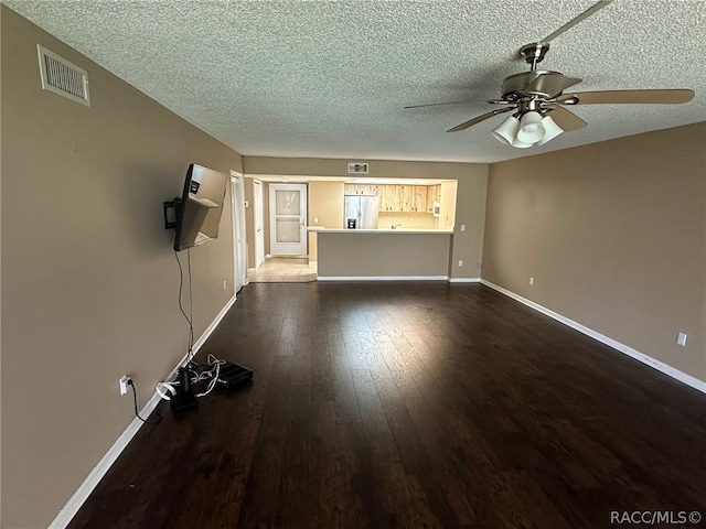 unfurnished living room featuring ceiling fan, wood-type flooring, and a textured ceiling