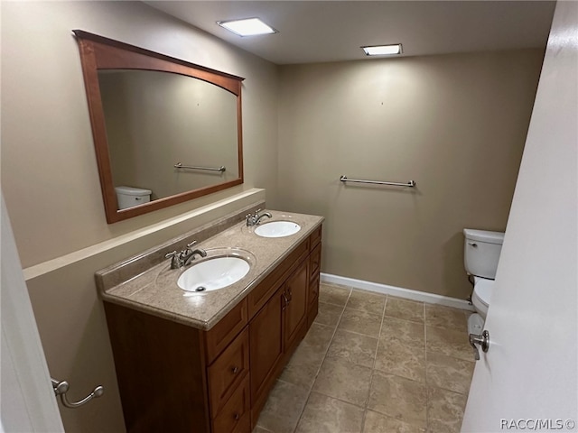 bathroom with tile patterned flooring, vanity, and toilet