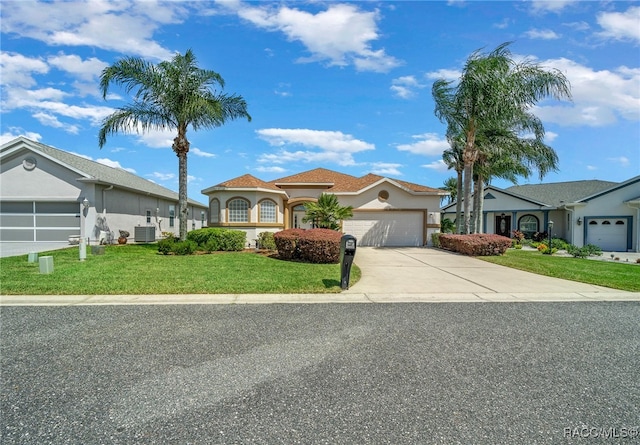 view of front of property featuring central AC, a front yard, and a garage