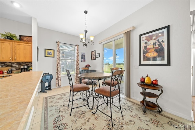 tiled dining area featuring a notable chandelier and a wealth of natural light