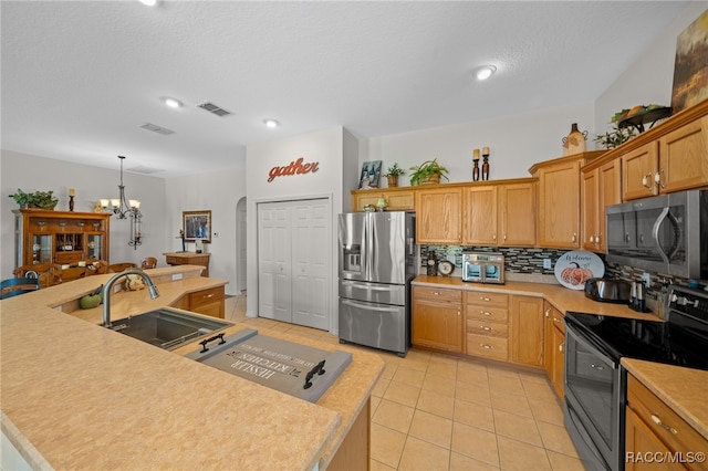 kitchen featuring sink, tasteful backsplash, a notable chandelier, decorative light fixtures, and appliances with stainless steel finishes