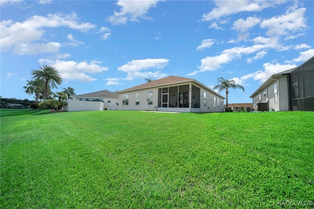 back of house with a lawn, a sunroom, and central AC unit