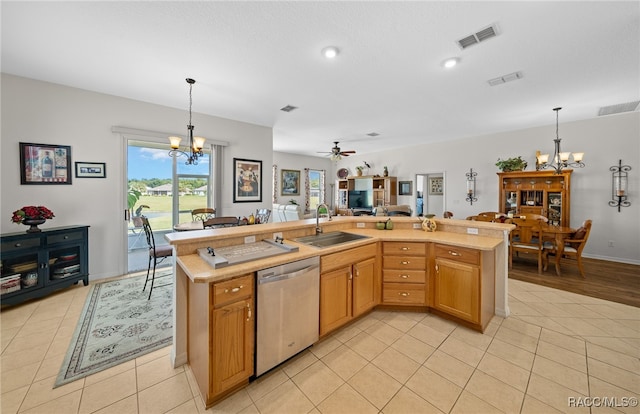 kitchen featuring ceiling fan with notable chandelier, sink, a center island with sink, dishwasher, and hanging light fixtures