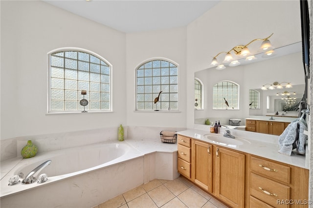 bathroom with a tub to relax in, tile patterned floors, and vanity