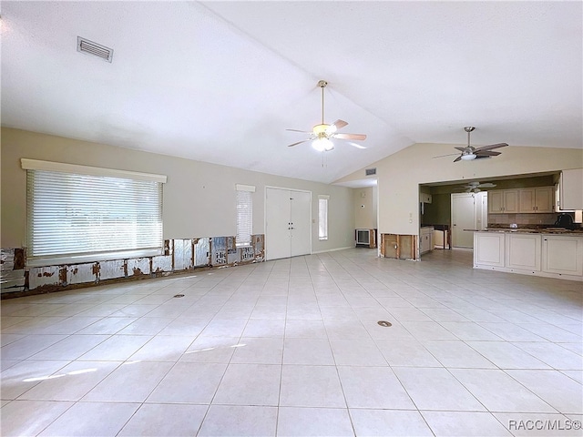 unfurnished living room featuring light tile patterned flooring, vaulted ceiling, and ceiling fan