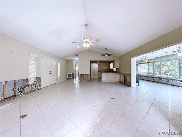 unfurnished living room with vaulted ceiling and light tile patterned floors