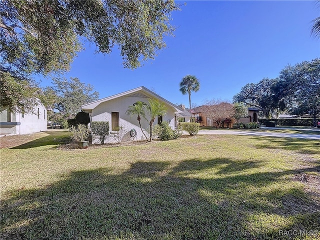 view of side of home with a yard