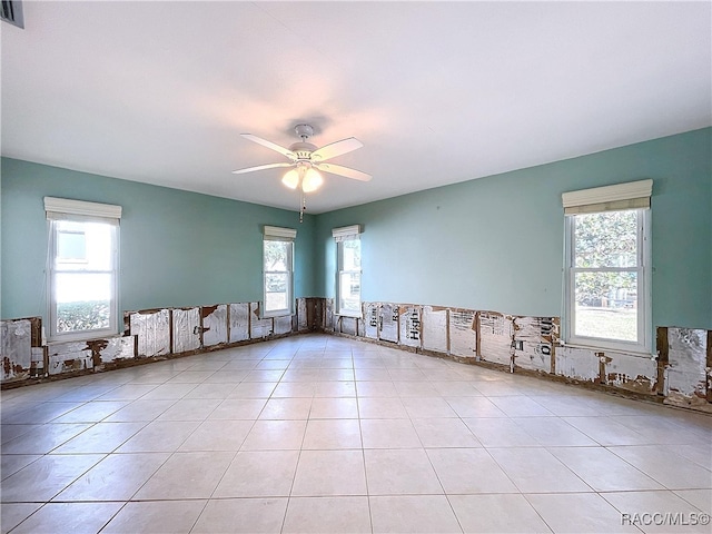 unfurnished room with ceiling fan, a healthy amount of sunlight, and light tile patterned floors