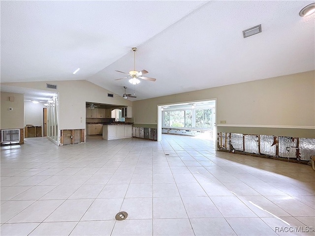 unfurnished living room featuring ceiling fan, lofted ceiling, and light tile patterned floors