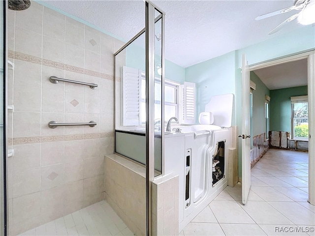 bathroom featuring tiled shower, a wealth of natural light, tile patterned floors, and ceiling fan