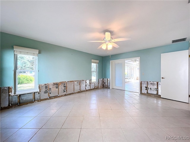 tiled spare room with ceiling fan