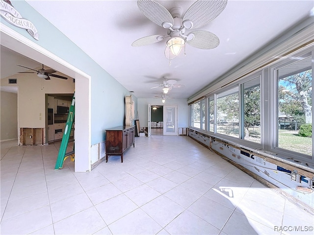 unfurnished sunroom with ceiling fan