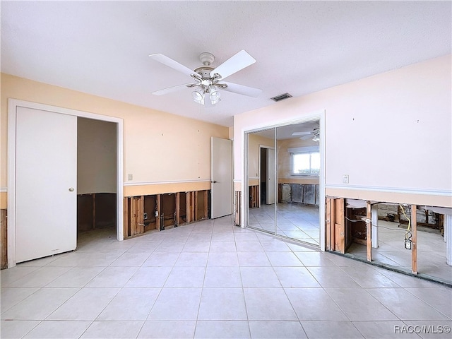 tiled empty room featuring ceiling fan