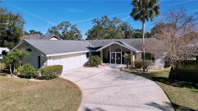 single story home featuring a garage and a front lawn