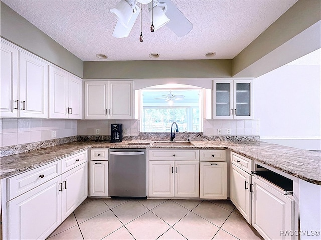 kitchen with sink, ceiling fan, light stone counters, white cabinets, and stainless steel dishwasher