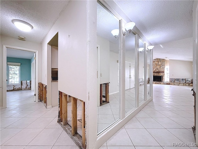 corridor featuring light tile patterned floors and a textured ceiling