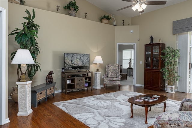 living room featuring dark hardwood / wood-style flooring, vaulted ceiling, and ceiling fan