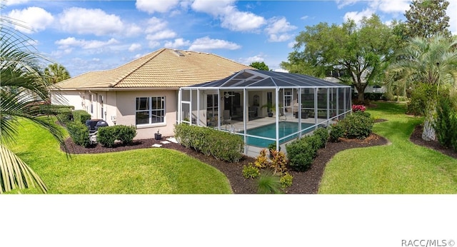 back of property with a lanai, a yard, and a patio