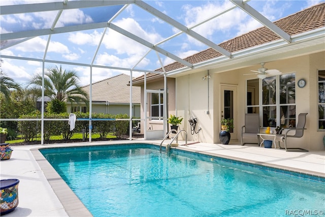 view of swimming pool featuring ceiling fan, a patio, and glass enclosure