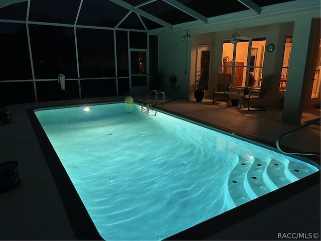 view of swimming pool featuring glass enclosure, ceiling fan, and a patio