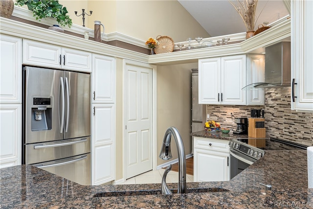 kitchen featuring dark stone counters, decorative backsplash, wall chimney exhaust hood, and stainless steel appliances