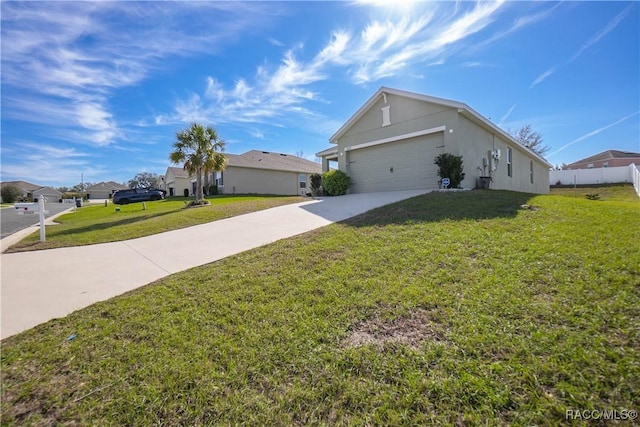 view of side of property featuring a garage, concrete driveway, a lawn, and stucco siding